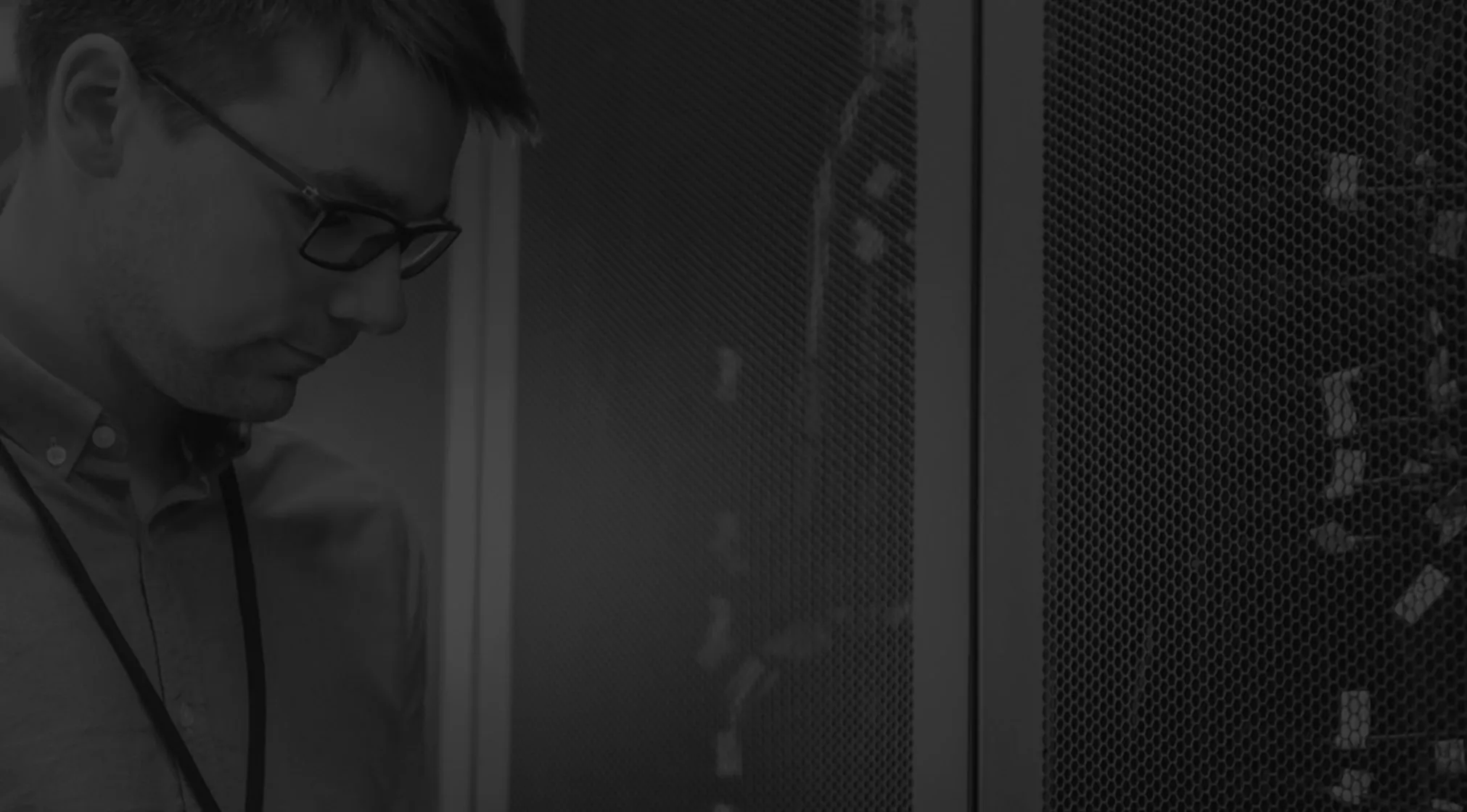 Técnico especialista revisando servidores o infraestructura IT en blanco y negro, representando soporte profesional.