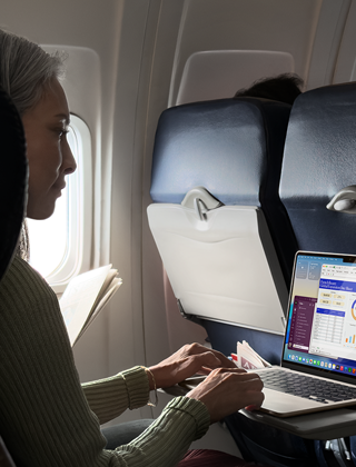 Una persona utiliza un MacBook Air en un avión para demostrar la gran autonomía del dispositivo