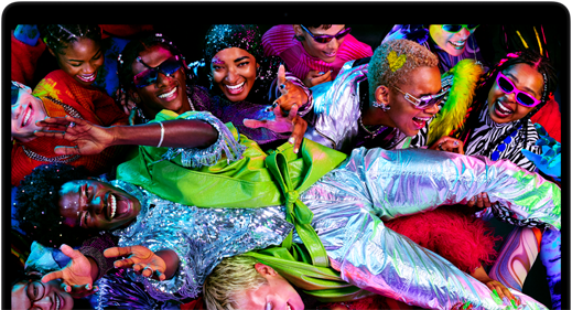 MacBook Pro con la pantalla a todo color que muestra a una persona llevada en volandas en una fiesta, destaca la nitidez de la pantalla Liquid Retina XDR
